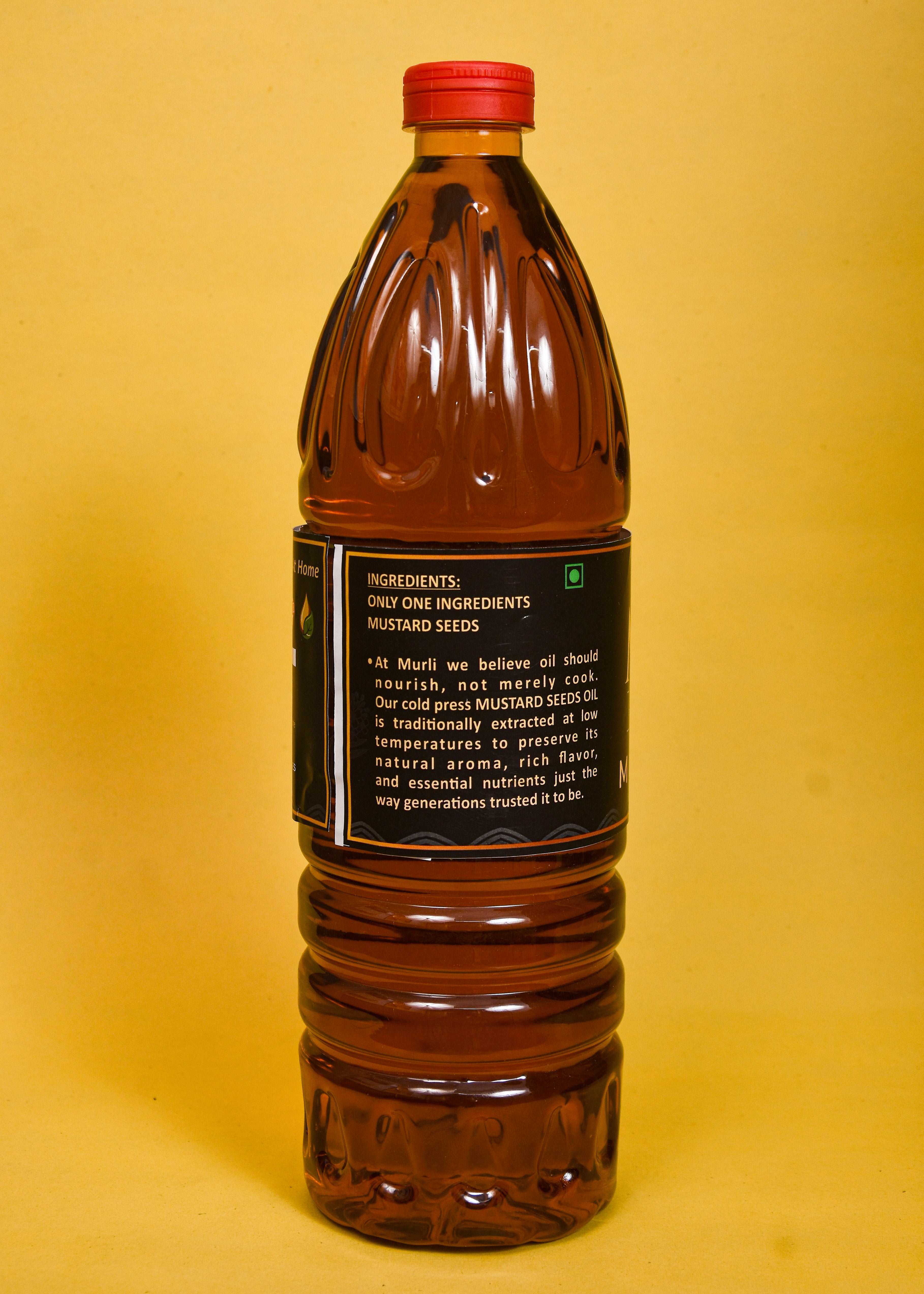 Cold pressed mustard seed oil in a clear bottle with red cap, highlighting natural ingredients and traditional extraction.